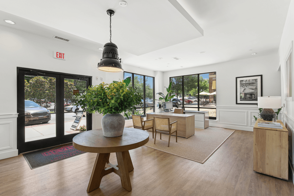 a living room with a table and chairs and a door to the street