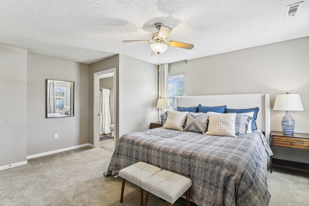 a bedroom with a bed and a ceiling fan