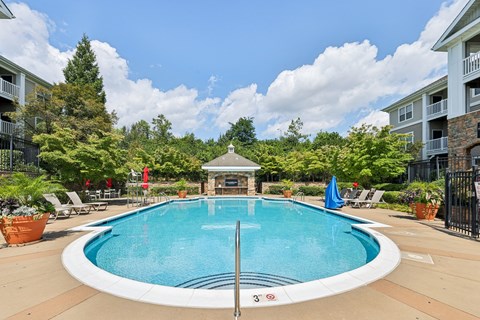A swimming pool surrounded by a fence and trees.