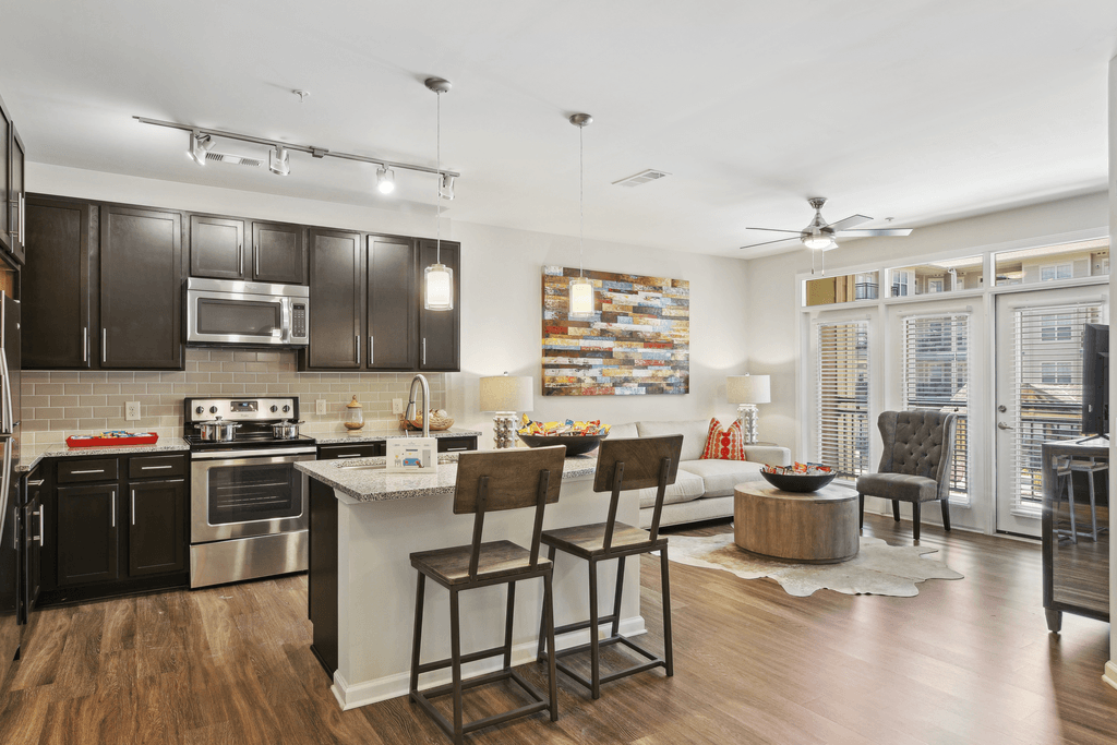 a kitchen and living room with a bar and stools