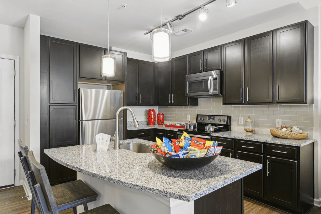 a kitchen with black cabinets and a granite counter top