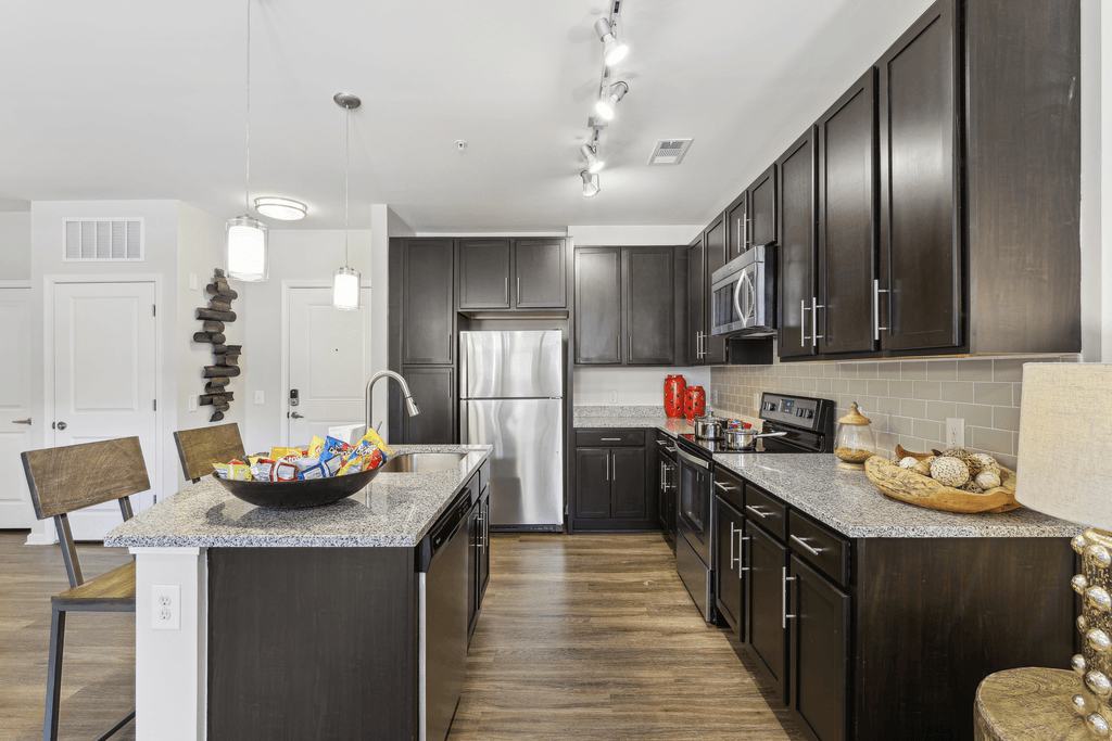 a large kitchen with dark cabinets and a counter top