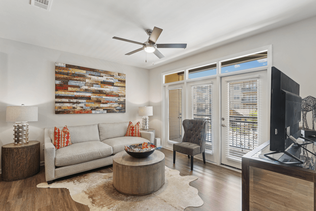 a living room with a couch and a ceiling fan