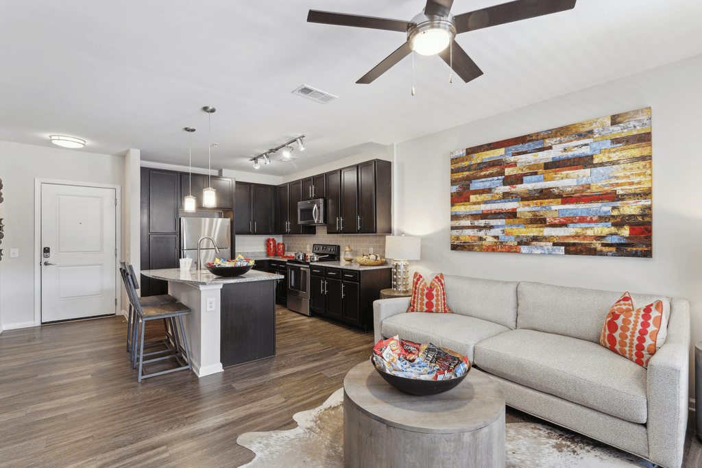 a living room with a couch and a kitchen with a