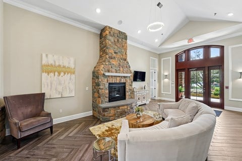 Clubhouse with a stone fireplace and a brown leather chair.