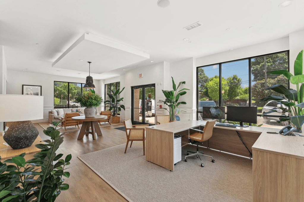 the living room has large windows and a large desk with a computer