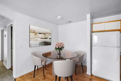 Cozy dining nook with glass table and refrigerator at Mayflower Harbor at Pilgrims Landing Apartments, Utah