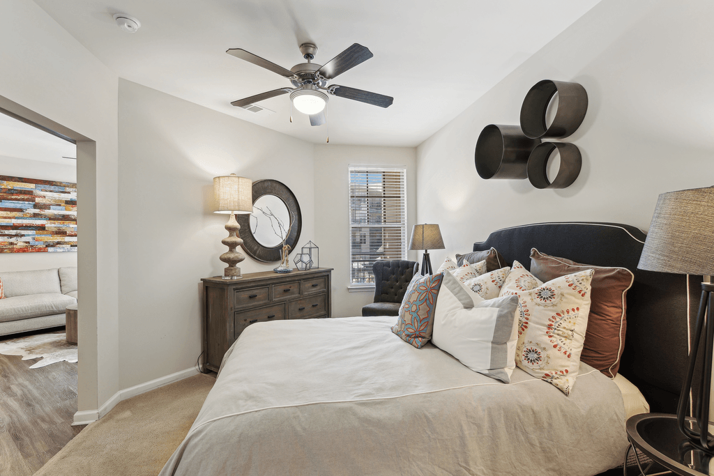 a bedroom with a large bed and a ceiling fan