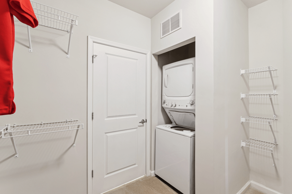 a white laundry room with a white door and a washer and dryer in