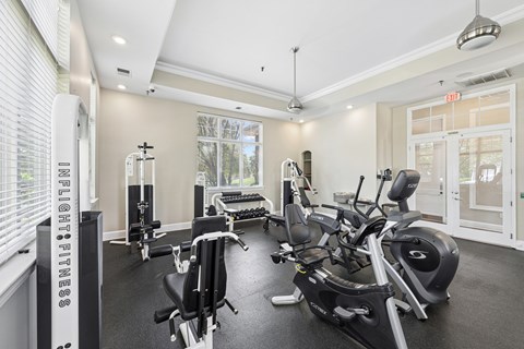 A gym with a row of exercise bikes and a weight machine.