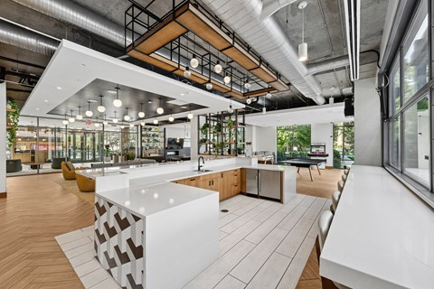 A modern kitchen with a white counter and wooden floors.