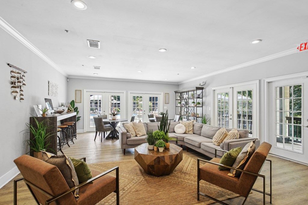 A living room with a brown sofa, a coffee table, and a glass door.