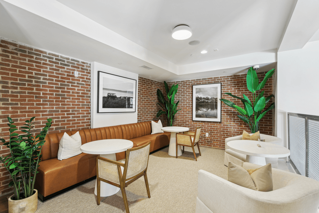 a living room with a brick wall and couches and tables