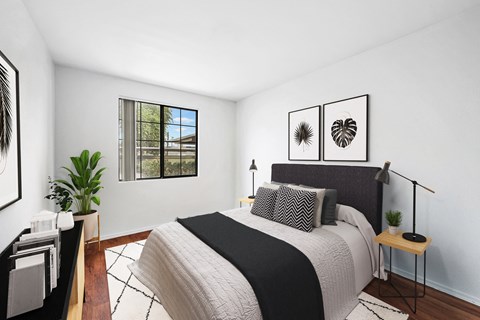 Bedroom with dark upholstered headboard and botanical prints at ReNue Downtown Apartments, Phoenix, AZ 85007
