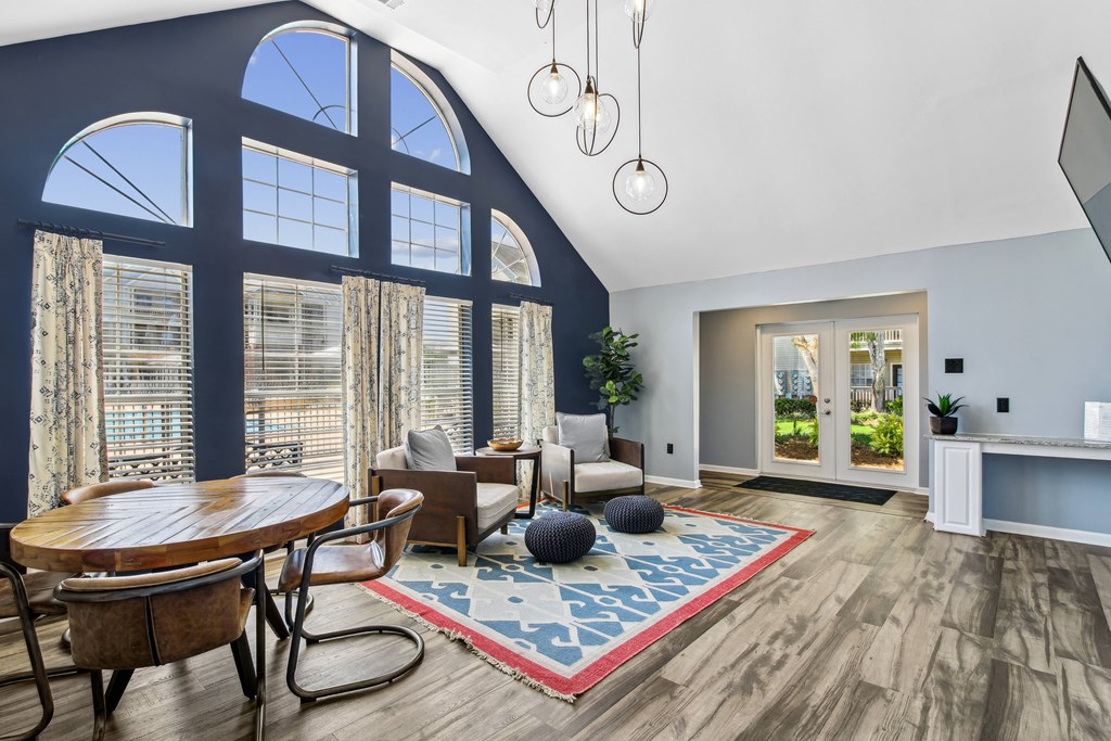 a living room with large windows and a table and chairs