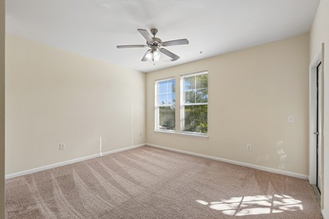 A room with a ceiling fan and a window.