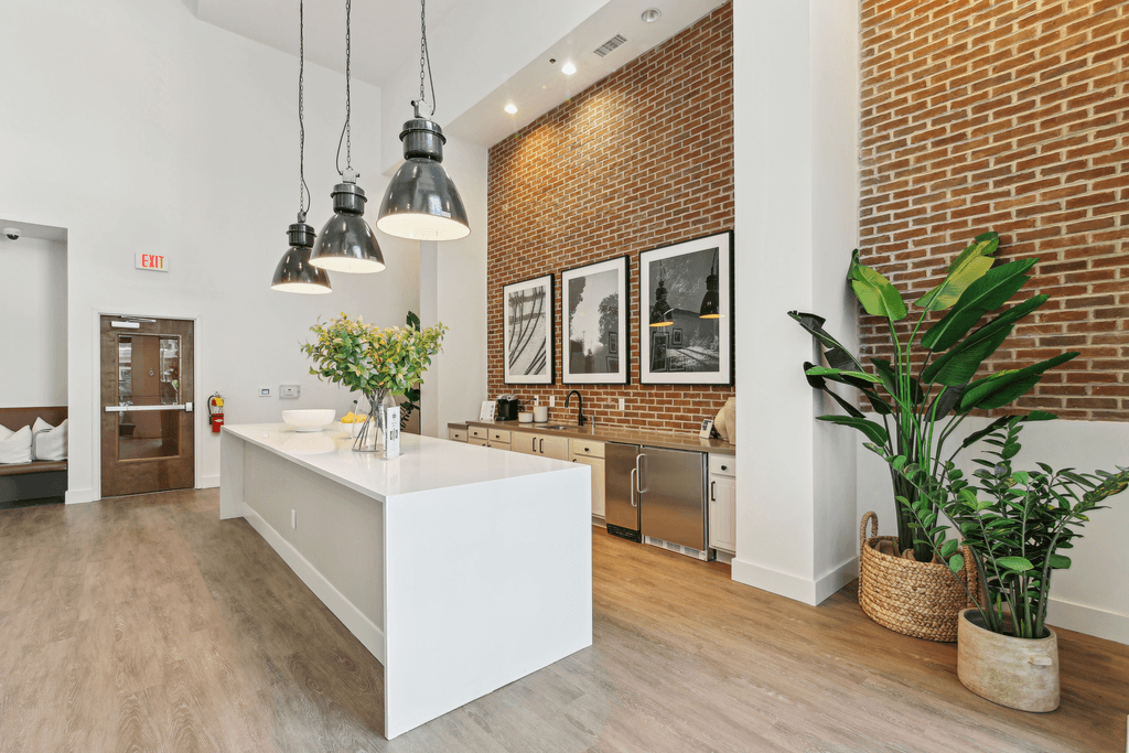 a kitchen with a white island and a brick wall