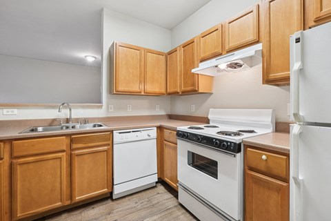 A kitchen with wooden cabinets and white appliances.
