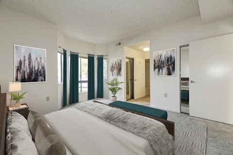 A bedroom with a large bed and a painting on the wall.