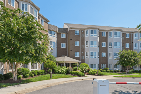 Apartment complex with a red and white barrier in front.