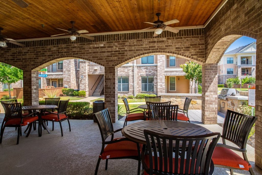 an outdoor patio with tables and chairs
