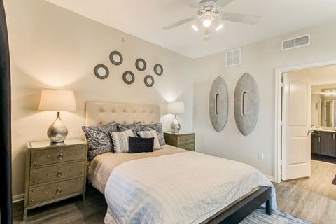 staged bedroom with hardwood-style flooring and ceiling fan