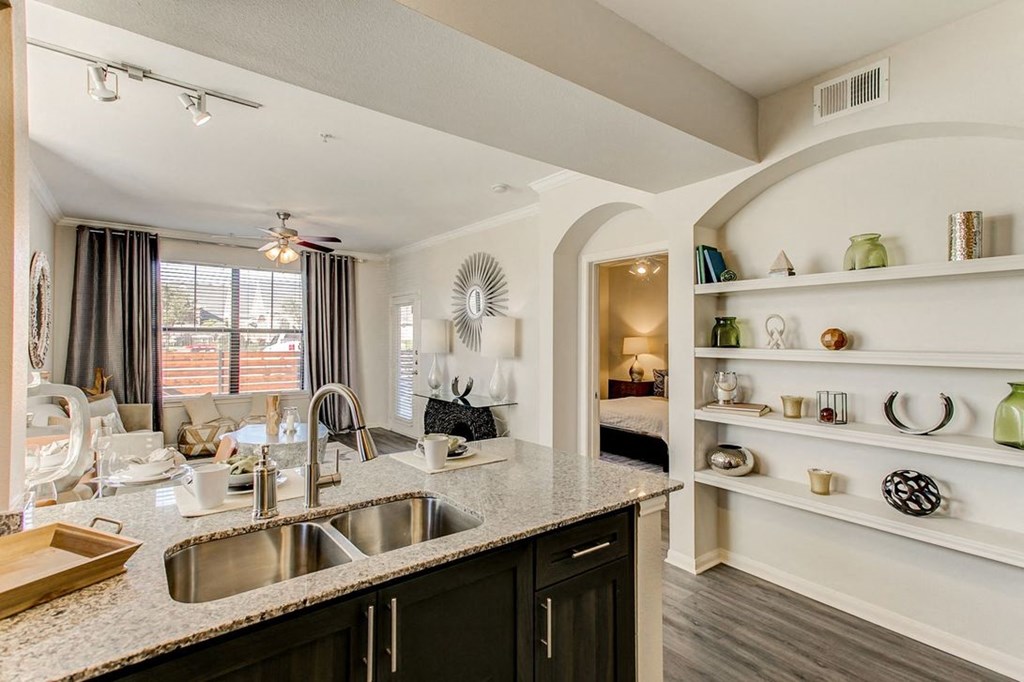 staged kitchen with granite-style countertops and built-in bookshelves