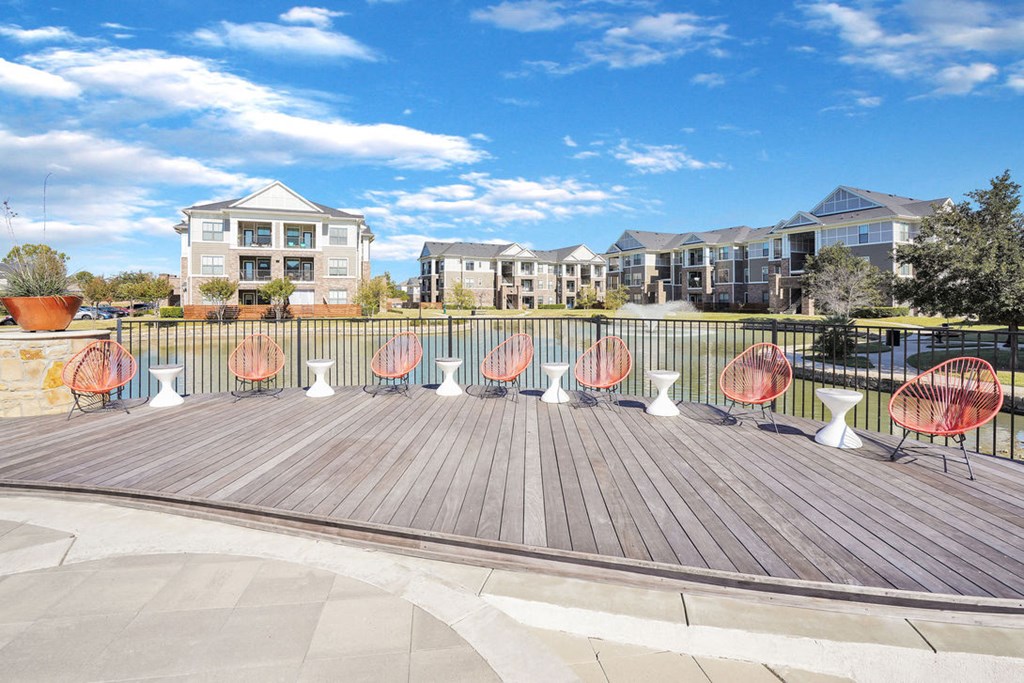 orange lounge chairs sitting on a wooden deck