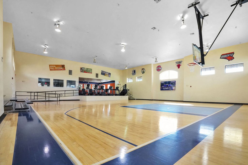 indoor basketball court with fitness equipment in the background