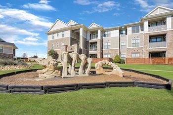 playground shaped like a dinosaur skeleton in front of an apartment building