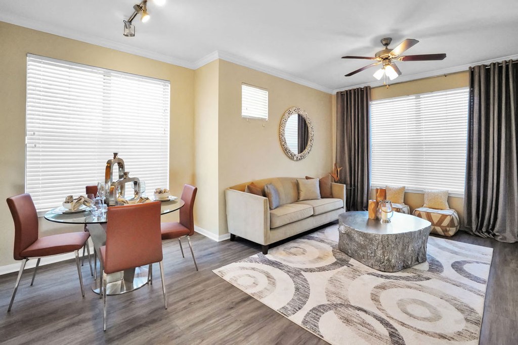 a staged living room with two windows and a ceiling fan
