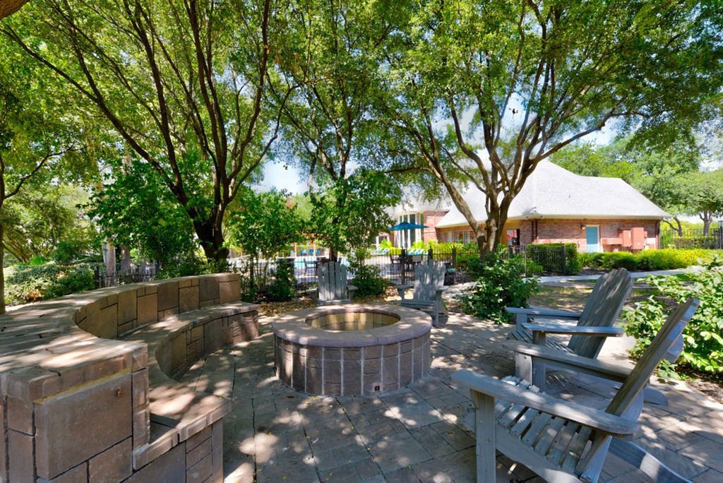 an outdoor patio with a firepit and chairs