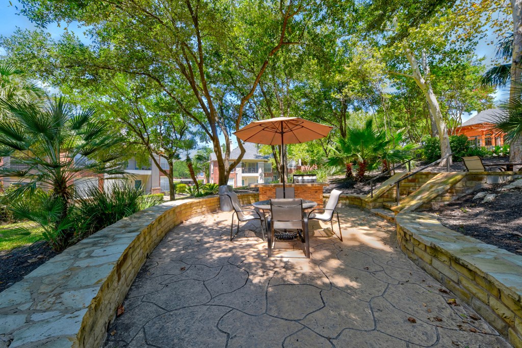 a patio with a table and chairs and an umbrella