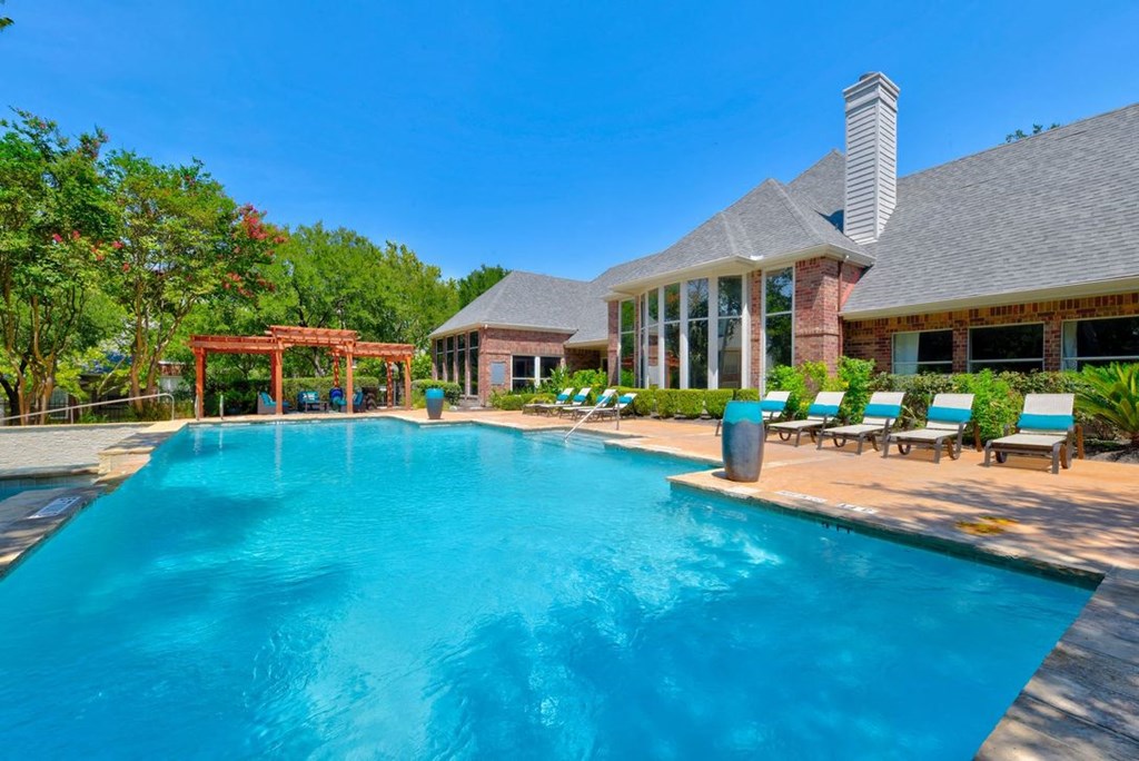a swimming pool with a clubhouse in the background