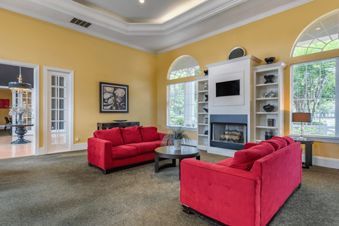 A living room with red couches and a fireplace.