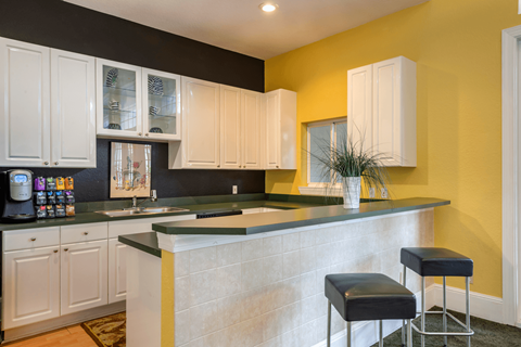 A kitchen with white cabinets and a black countertop.