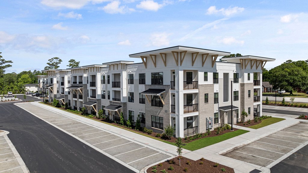 an aerial view of an apartment complex with a parking lot