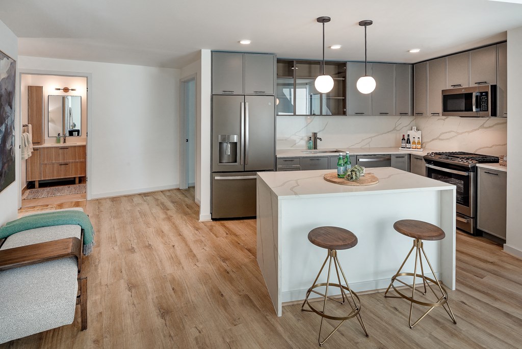 a kitchen with a white island and stainless steel appliances