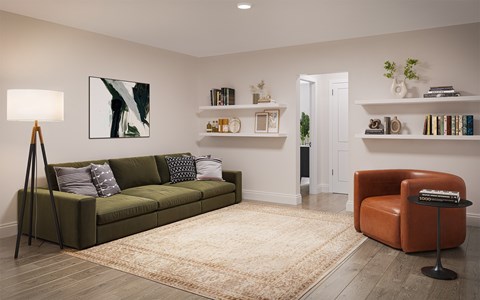 A living room with a green couch, a brown leather chair, and a rug.