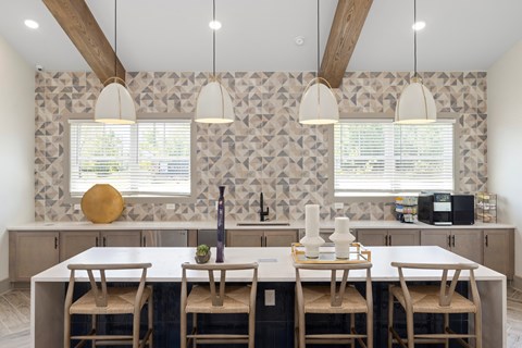 A kitchen with a table and chairs in front of a patterned wallpapered wall.