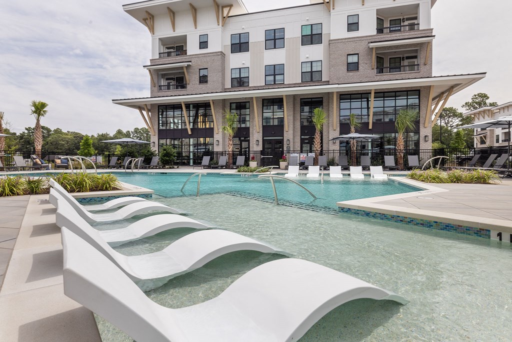 A modern building with a pool in front.