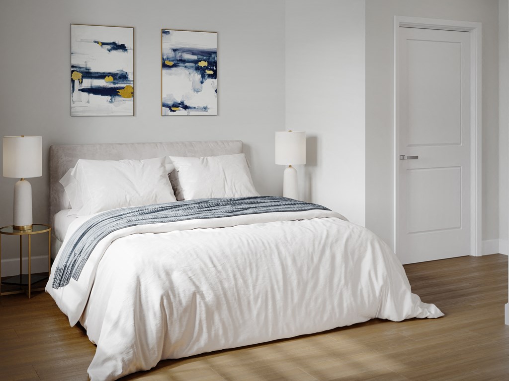 a bedroom with a white comforter on a bed
