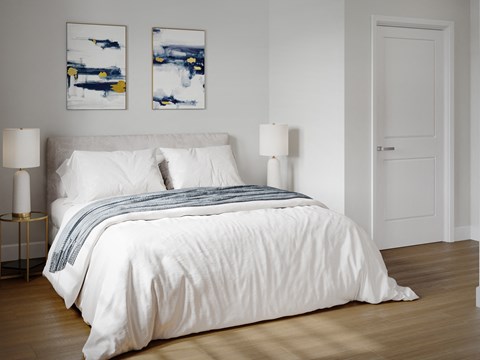 a bedroom with a white comforter on a bed
