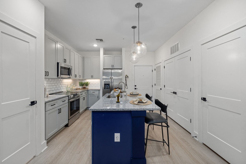 a kitchen with white cabinets and a blue counter top