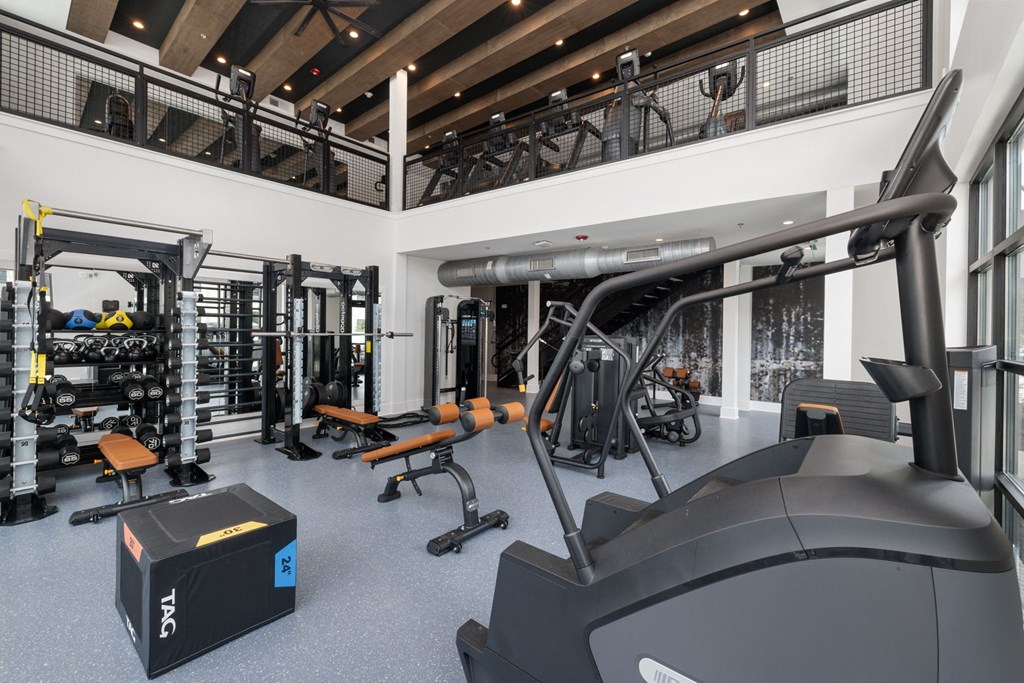 a gym with treadmills and other exercise equipment in a large room with windows