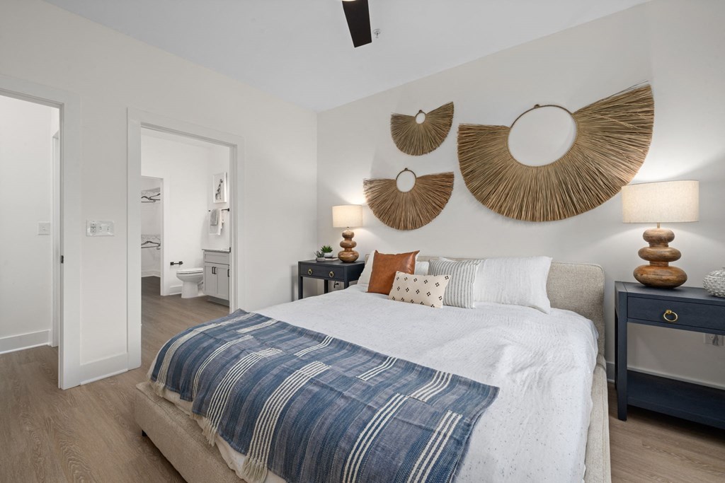 a bedroom with a bed and two mirrors on the wall