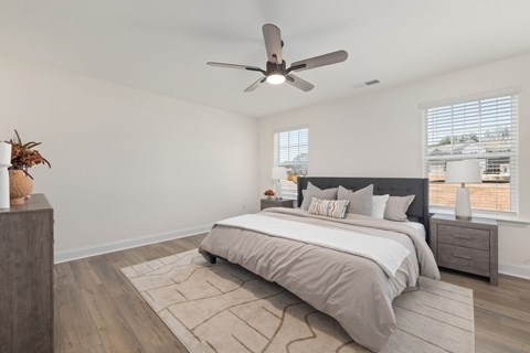 A bedroom with a large bed and a ceiling fan.