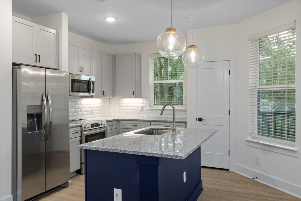 a kitchen with white cabinets and a granite counter top