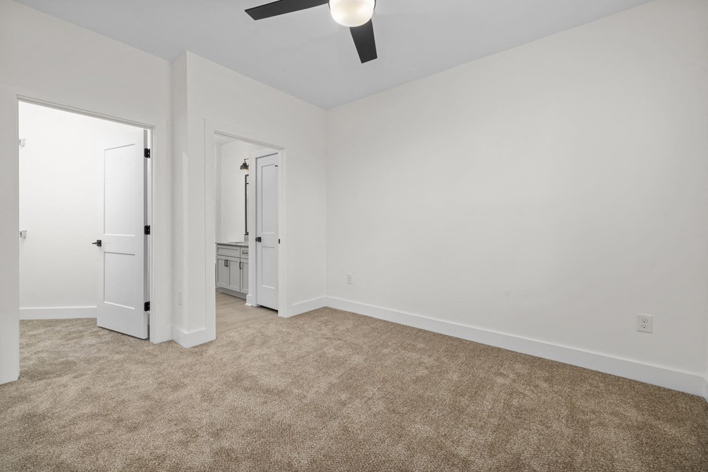an empty living room with white walls and carpet