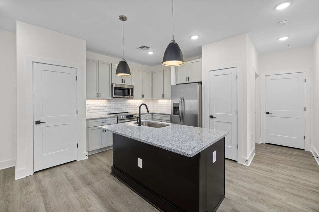 a kitchen with white cabinets and a granite counter top